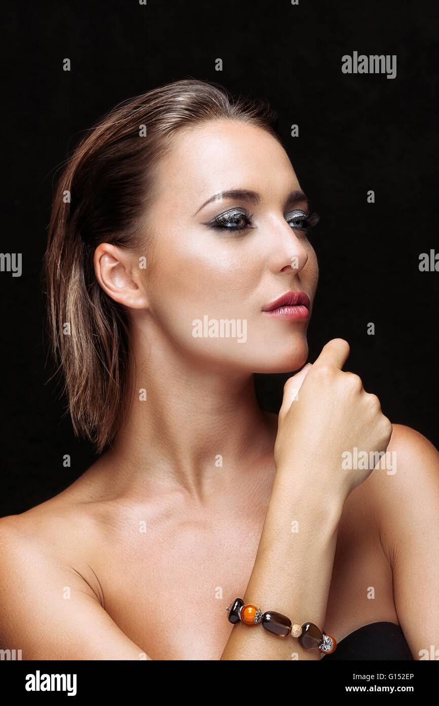 Portrait of a young woman's hand on chin, à la recherche sur le côté Banque D'Images