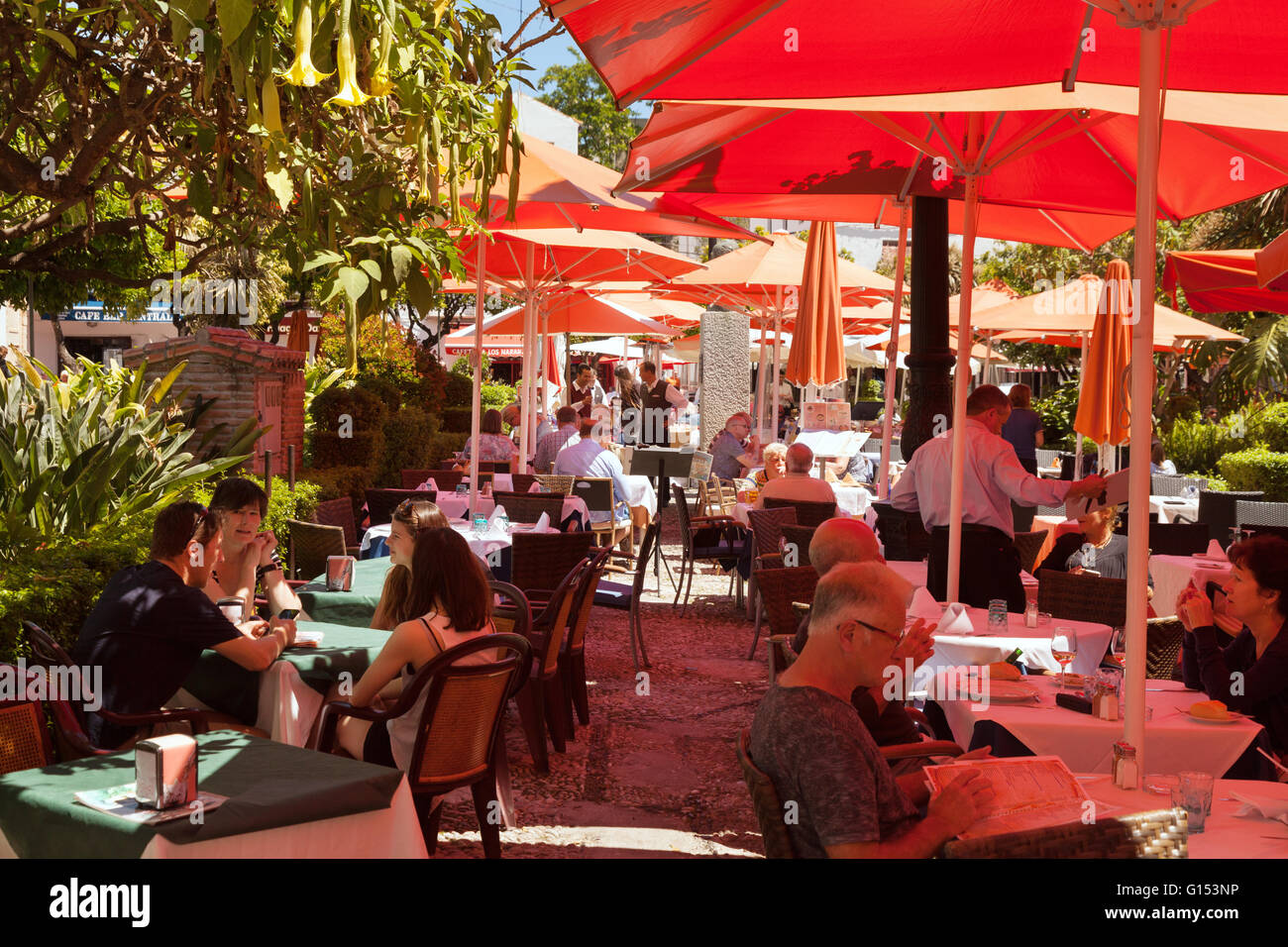Les gens de boire à un café de la rue, la Plaza de los Naranjos ( carré orange ), vieille ville de Marbella, Costa del Sol, Andalousie Espagne Banque D'Images