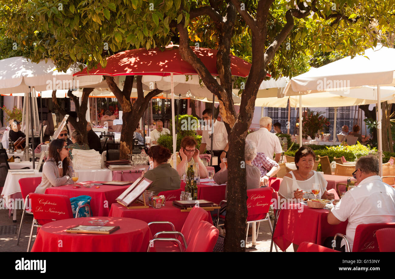 Les gens de boire à un café de la rue, la Plaza de los Naranjos ( carré orange ), vieille ville de Marbella, Costa del Sol, Andalousie Espagne Banque D'Images