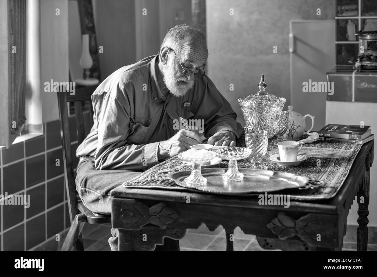 Tom écrit dans son journal dans la cuisine de notre chambre d'hôtel dans une maison historique à Kashan, Iran. Banque D'Images