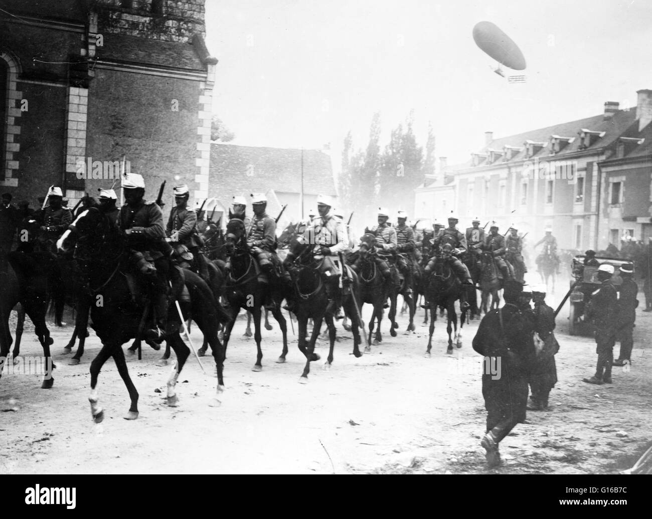 Soldats français à cheval dans la rue, avec un dirigeable voler dans l'air derrière eux au cours de la Première Guerre mondiale ou de cavalerie cavaliers étaient des soldats ou des guerriers qui ont combattu à cheval monté. Un soldat de la cavalerie est connu par un certain nombre de désignations telles que cava Banque D'Images