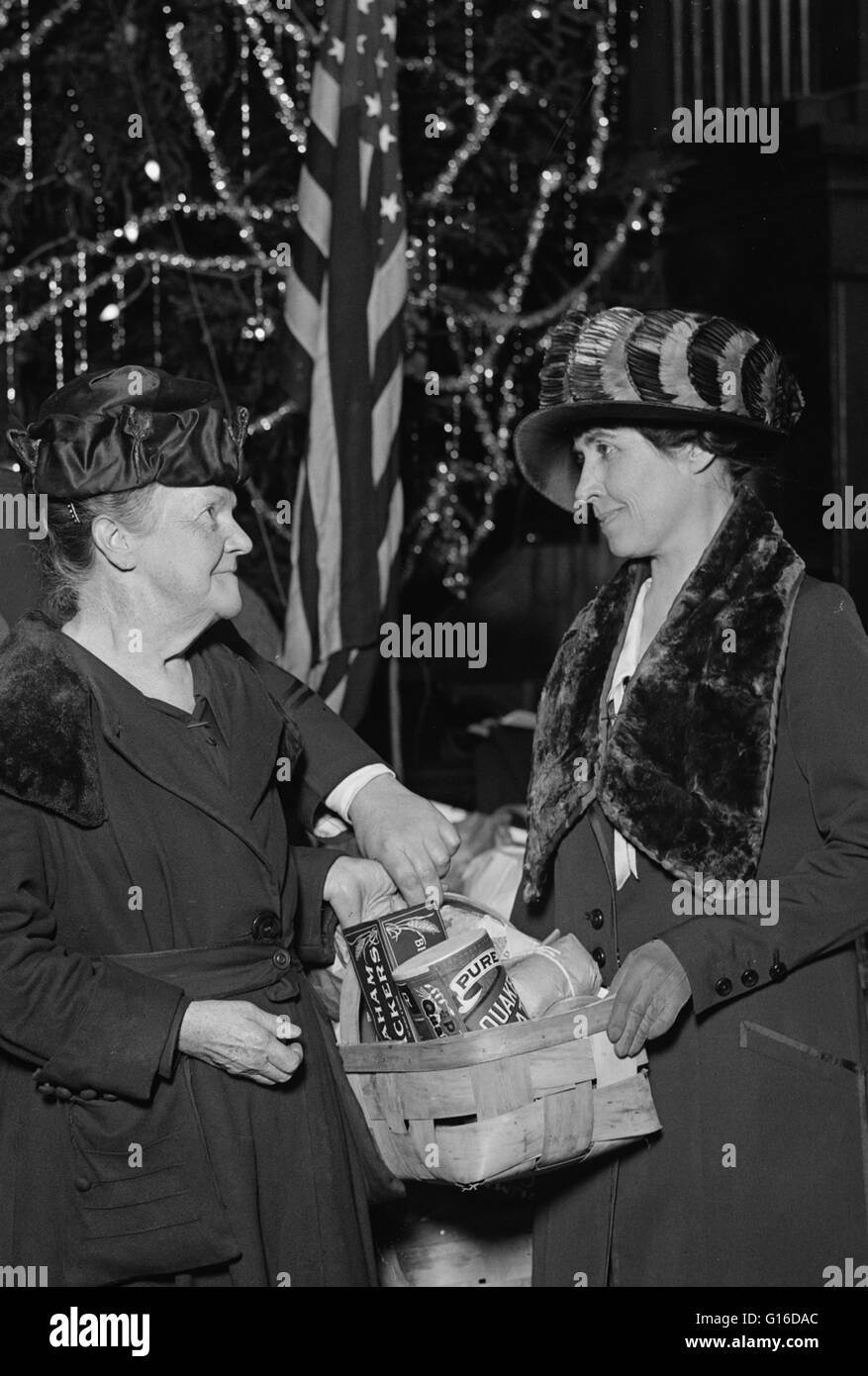 Intitulé : 'Mrs. Coolidge à l'Armée du Salut' montrant la Première Dame Grace Coolidge avec paniers de nourriture en face de sapin de Noël. Grace Anna Goodhue Coolidge (3 janvier 1879 - 8 juillet 1957) était l'épouse de Calvin Coolidge et la Première Dame des États-Unis fr Banque D'Images