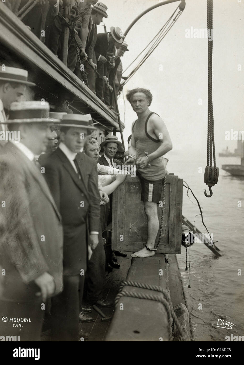 Intitulé : 'Harry Houdini entrer dans une caisse qui sera abaissé dans le port de New York dans le cadre d'une évasion stunt le 7 juillet 1912 montrant des hommes debout sur le côté d'une barge dans le port de New York comme Harry Houdini pas dans une caisse sur le bord de la b Banque D'Images