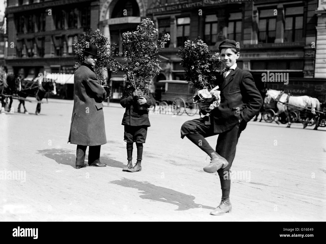 Intitulé : "Les hommes tenant des fleurs de Pâques, New York.' Pâques est une fête chrétienne annuelle en commémoration de la résurrection de Jésus-Christ, célébrée le premier dimanche après la première pleine lune après l'équinoxe vernal, calculée conformément à l'tabl Banque D'Images