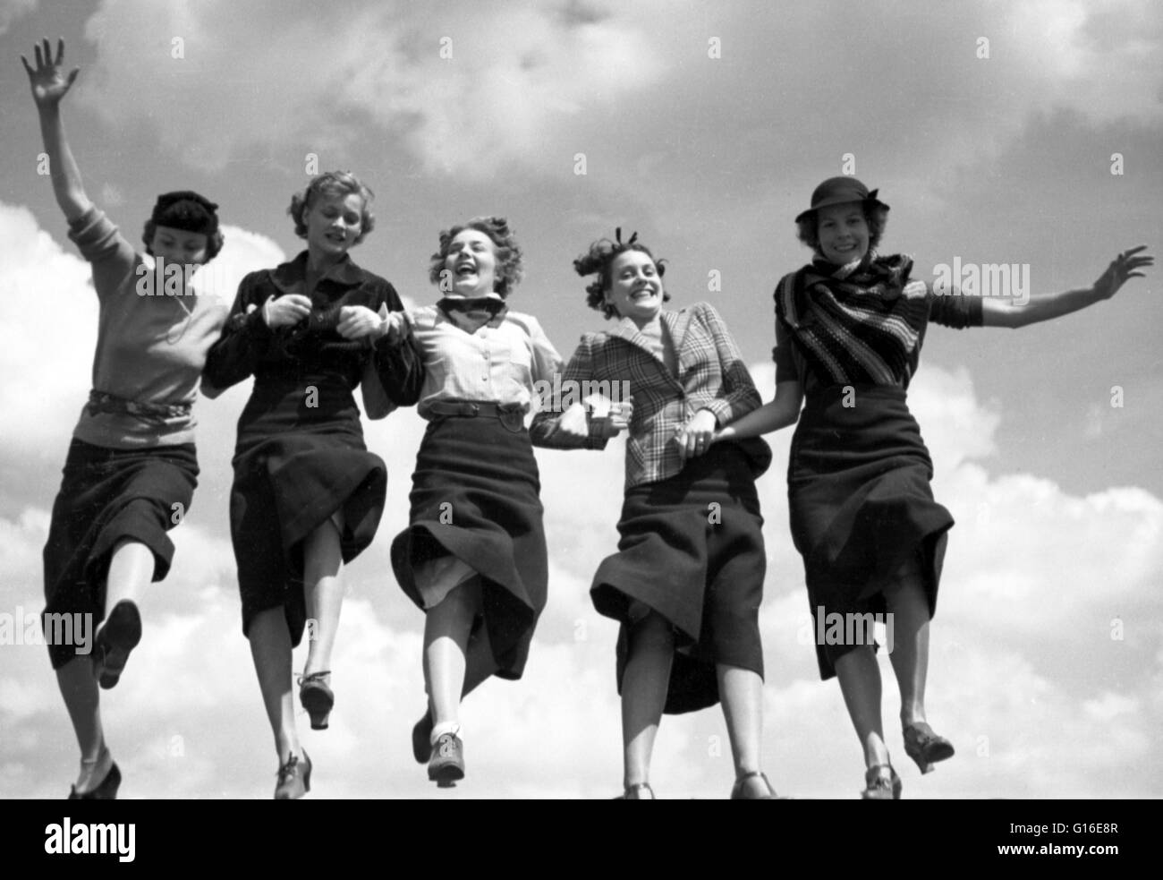 Intitulé : "Cinq femmes se tenant la main et marcher ensemble dans une rangée, ciel en arrière-plan' photographié par Toni Frissell pour Vogue Magazine Août 1935. La mode est un élément distinctif et souvent tendance habituelle dans le style de robes d'une personne. C'est l'emporter Banque D'Images