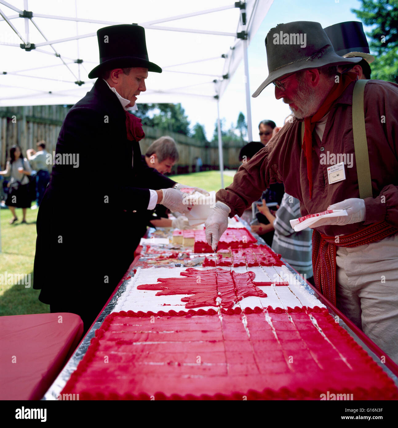 La célébration de la fête du Canada à Fort Langley, BC, en Colombie-Britannique, Canada - coupe reconstitueurs grand gâteau décoré comme un drapeau canadien Banque D'Images
