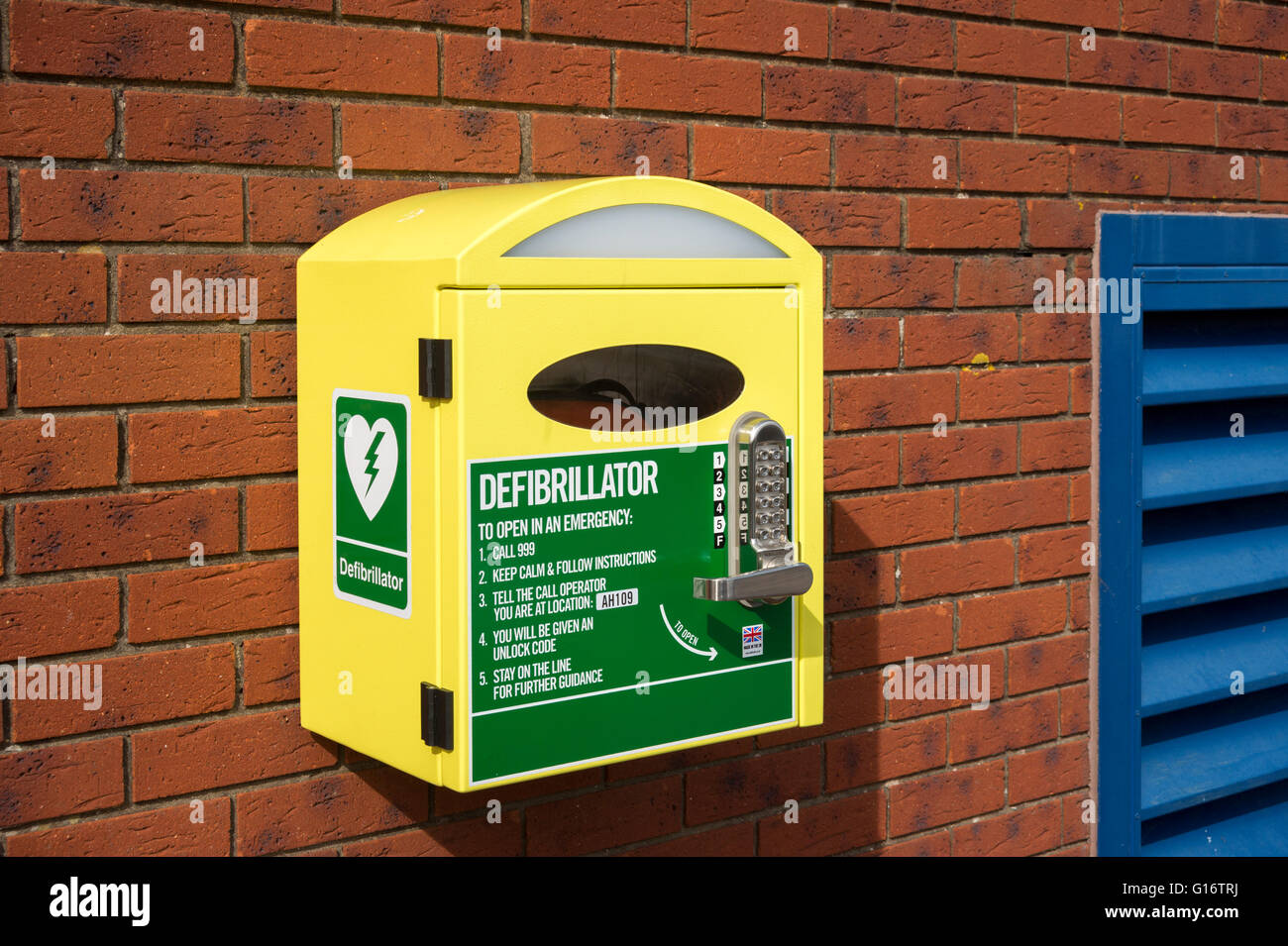 Défibrillateur dans une boîte jaune sur un mur extérieur Banque D'Images