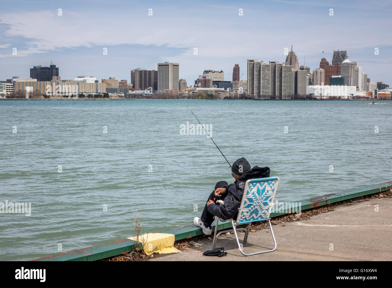 Homme assis dans une chaise longue à la pêche dans la rivière Detroit  Windsor sur le côté de la rivière du Canada Photo Stock - Alamy