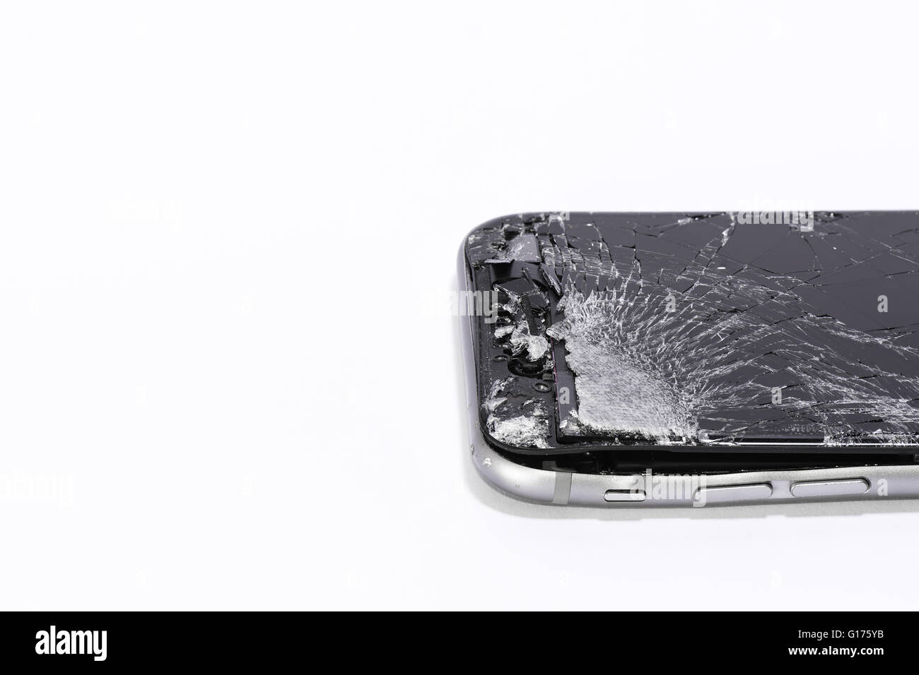 Un téléphone mobile avec écran fissuré sur un fond blanc Banque D'Images