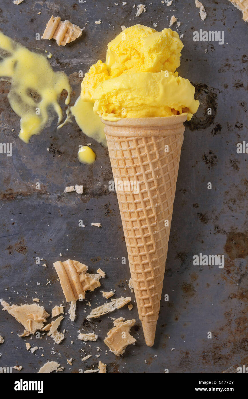 La crème glacée mangue fait maison en cornet gaufré avec plus de miettes de gaufrettes rusty metal background. Vue d'en haut Banque D'Images