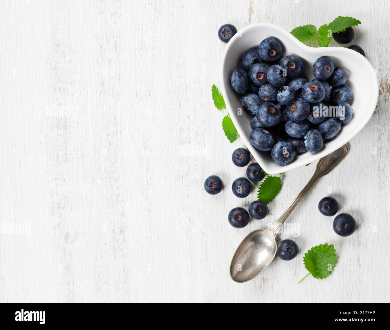 Petit-déjeuner sain de muesli, petits fruits avec du yogourt et des graines sur fond blanc - alimentation saine, régime alimentaire, Detox, nettoyer ou manger Veg Banque D'Images