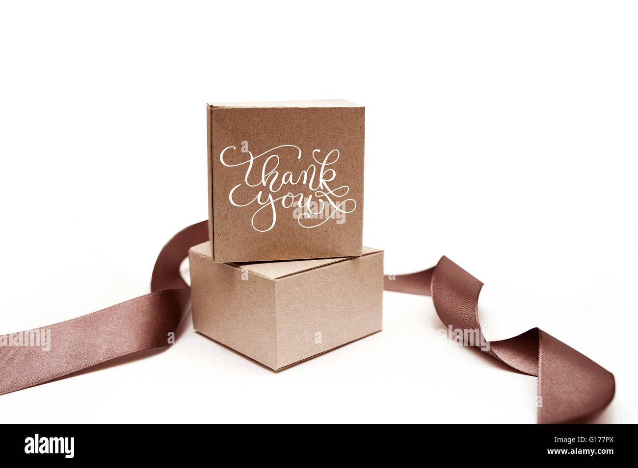 Boîtes cadeaux avec ruban brun sur un fond blanc et texte merci Banque D'Images
