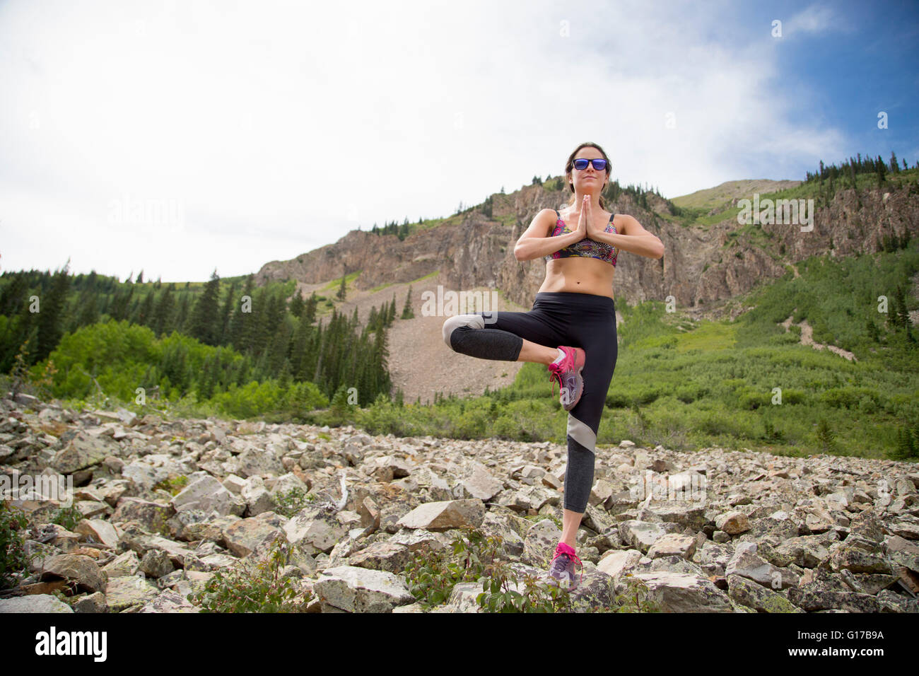 Woman practicing yoga on rocks, Aspen, Colorado Banque D'Images