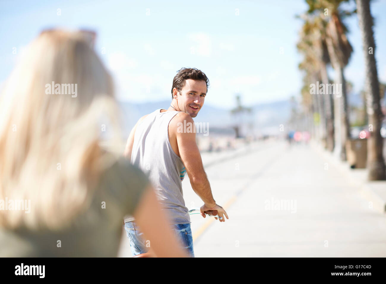 Retour à l'homme à la petite amie tout en cyclisme à Venice Beach, Los Angeles, Californie, USA Banque D'Images