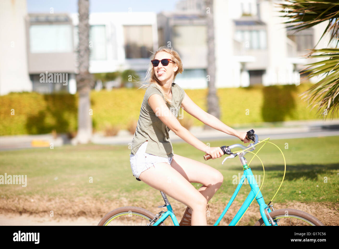 Jeune femme à la Par-dessus son épaule tandis que le vélo à Venice Beach, Los Angeles, Californie, USA Banque D'Images