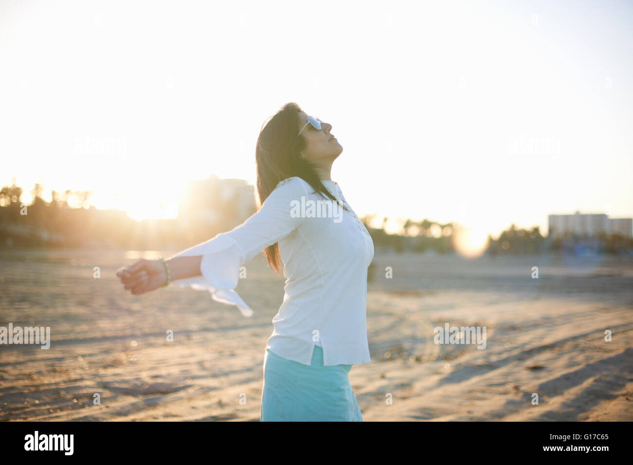Woman with arms open sur Santa Monica beach at sunset, Crescent City, California, USA Banque D'Images