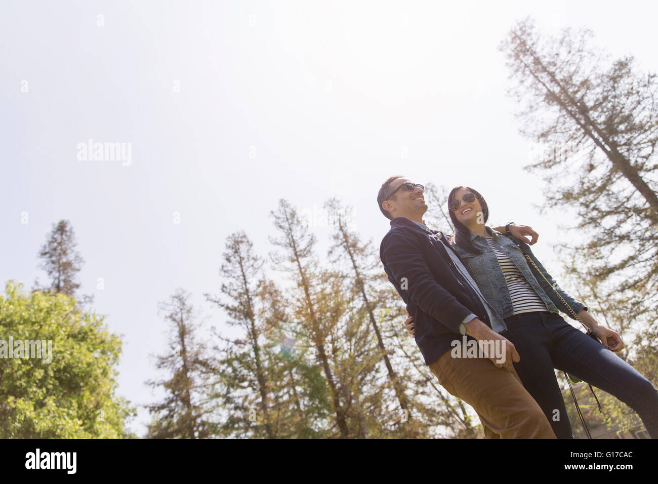 Low angle view of couple strolling wearing sunglasses Banque D'Images