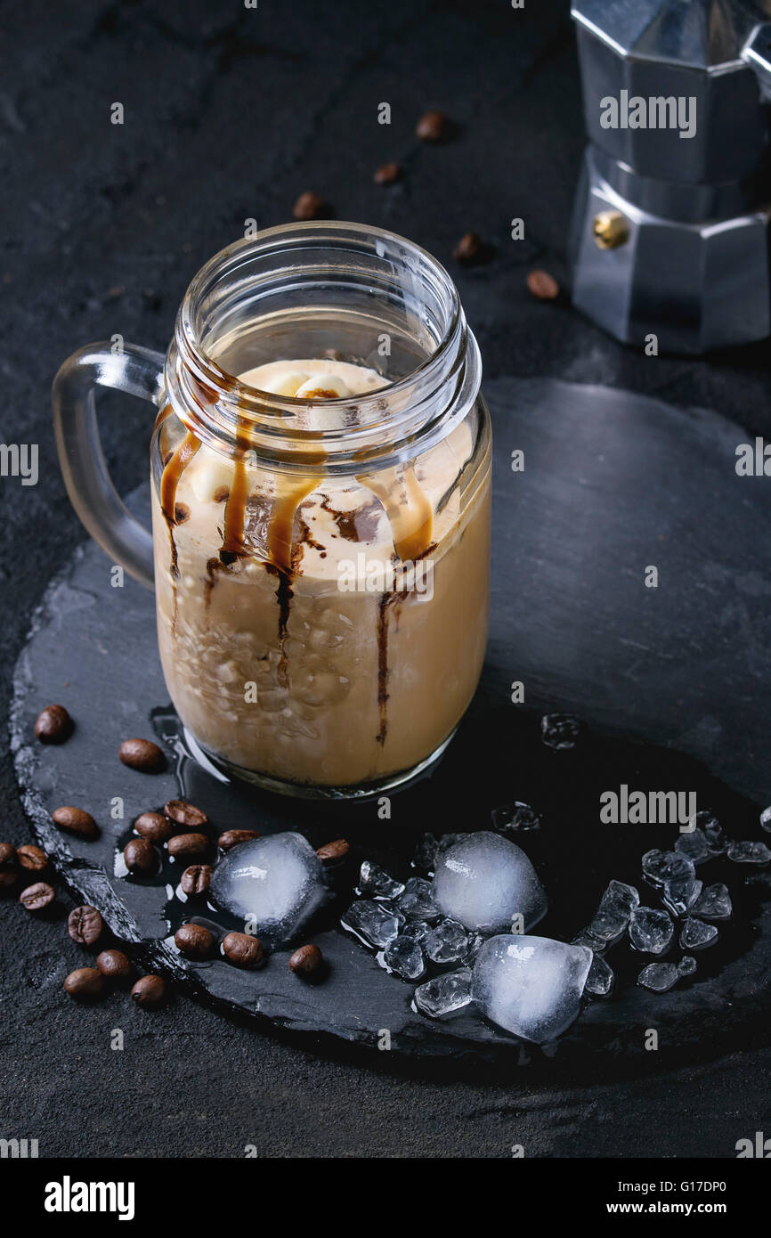 Glace en verre pot Mason de café avec de la crème glacée et sauce au  chocolat, servi avec des grains de café et des cubes de glace sur ardoise  bord vo Photo