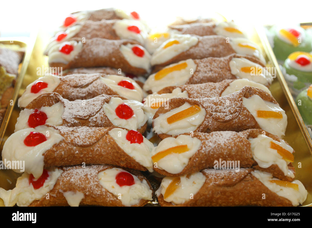 De nombreux cannoli siciliens avec de la crème anglaise et les cerises ou fruits confits Banque D'Images