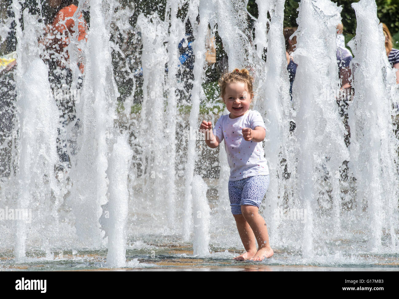 Un jeune bénéficie d'eaux de refroidissement de la fontaine à Sheffield le Goodwin's Peace Gardens comme la température augmente Banque D'Images