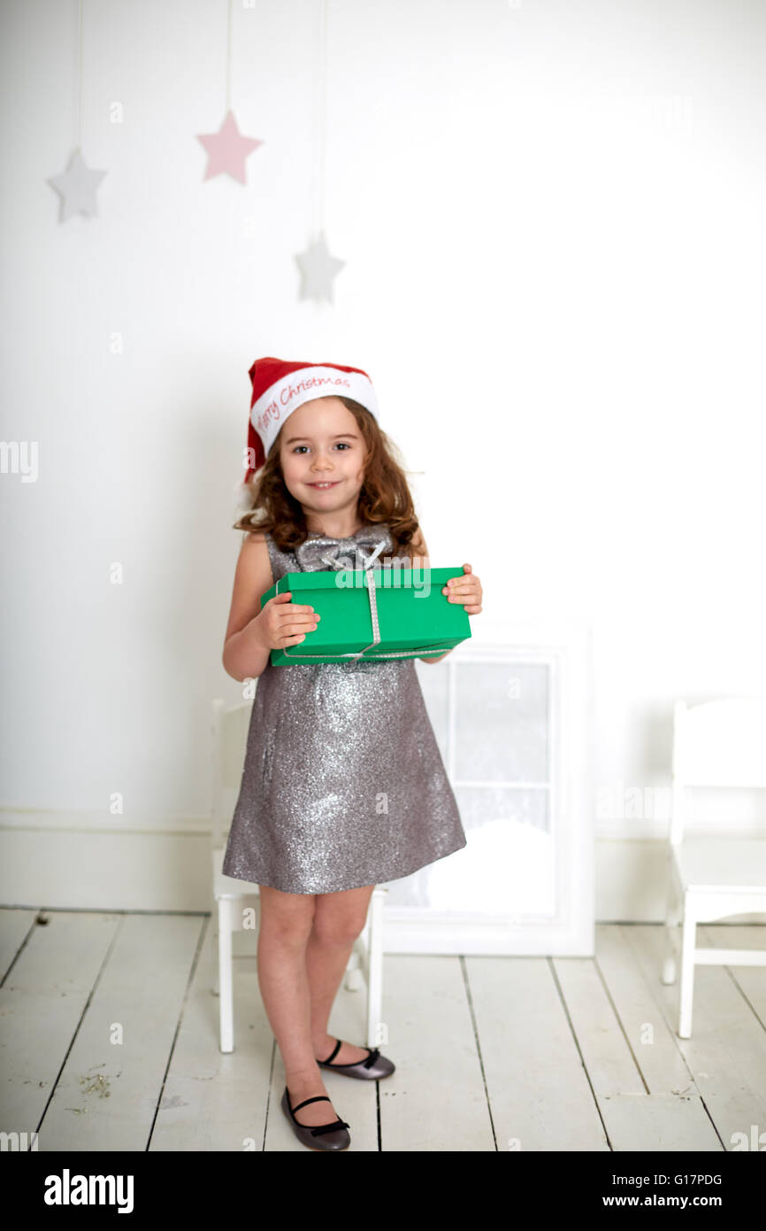 Girl in santa hat carrying Christmas Gift Banque D'Images