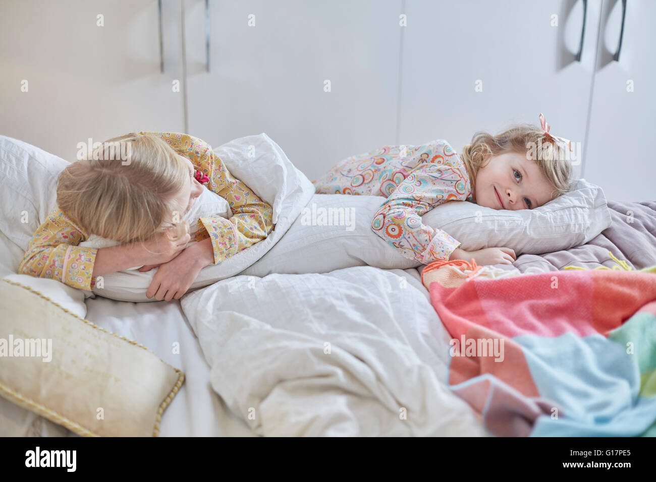 Les filles en pyjama la rêvasserie au lit Banque D'Images