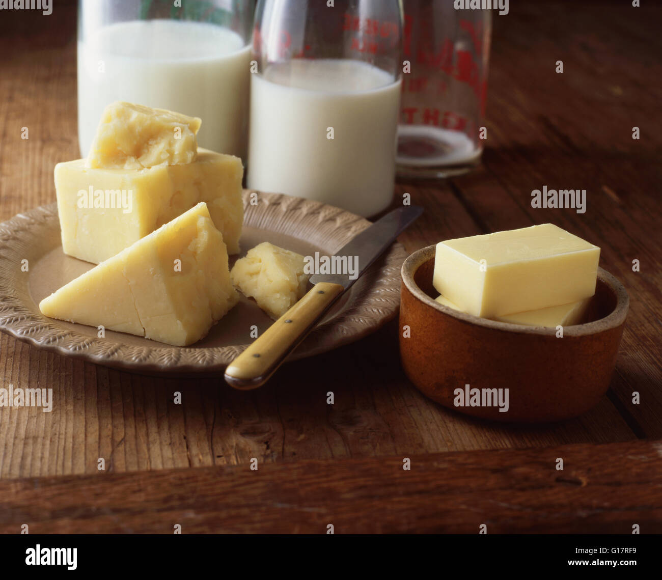 Le fromage, le beurre et la bouteille de lait sur la table en bois Banque D'Images