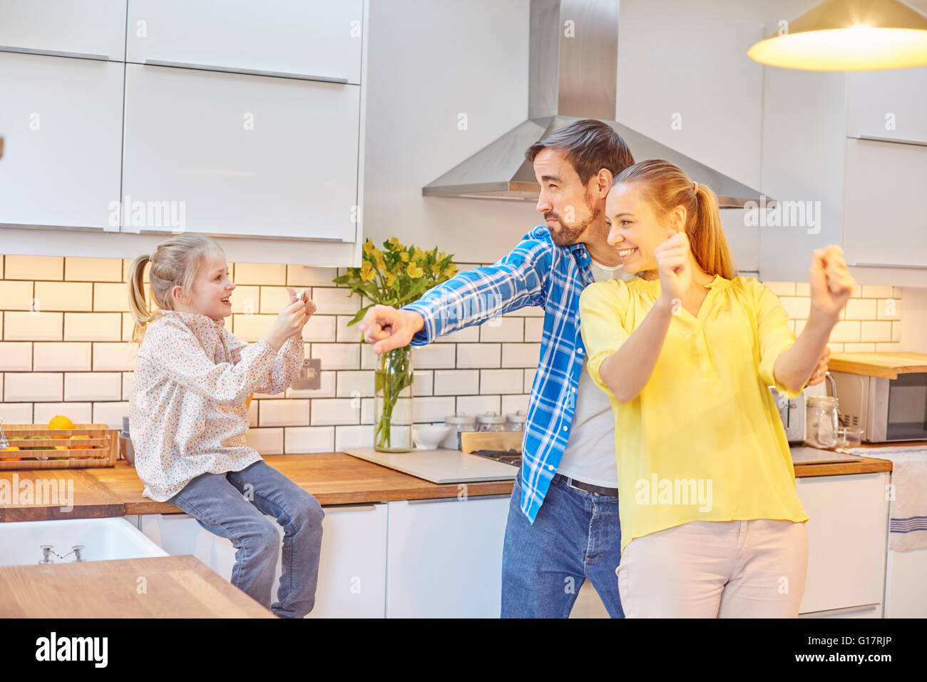 Fille drôle de parents dans la cuisine Banque D'Images
