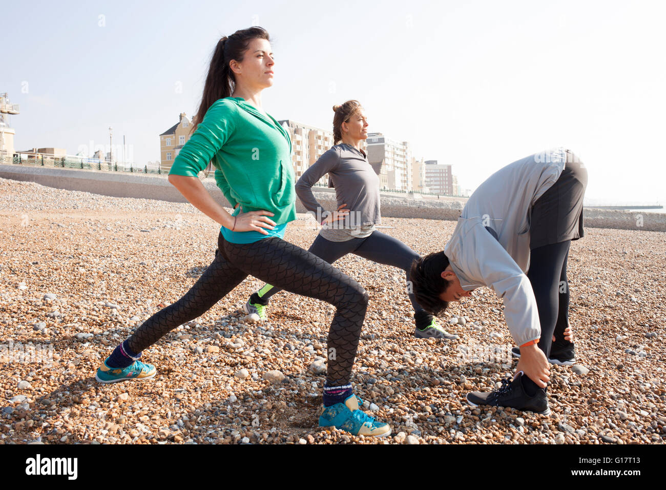 Homme et femmes réchauffer la formation, qui s'étend sur la plage de Brighton Banque D'Images