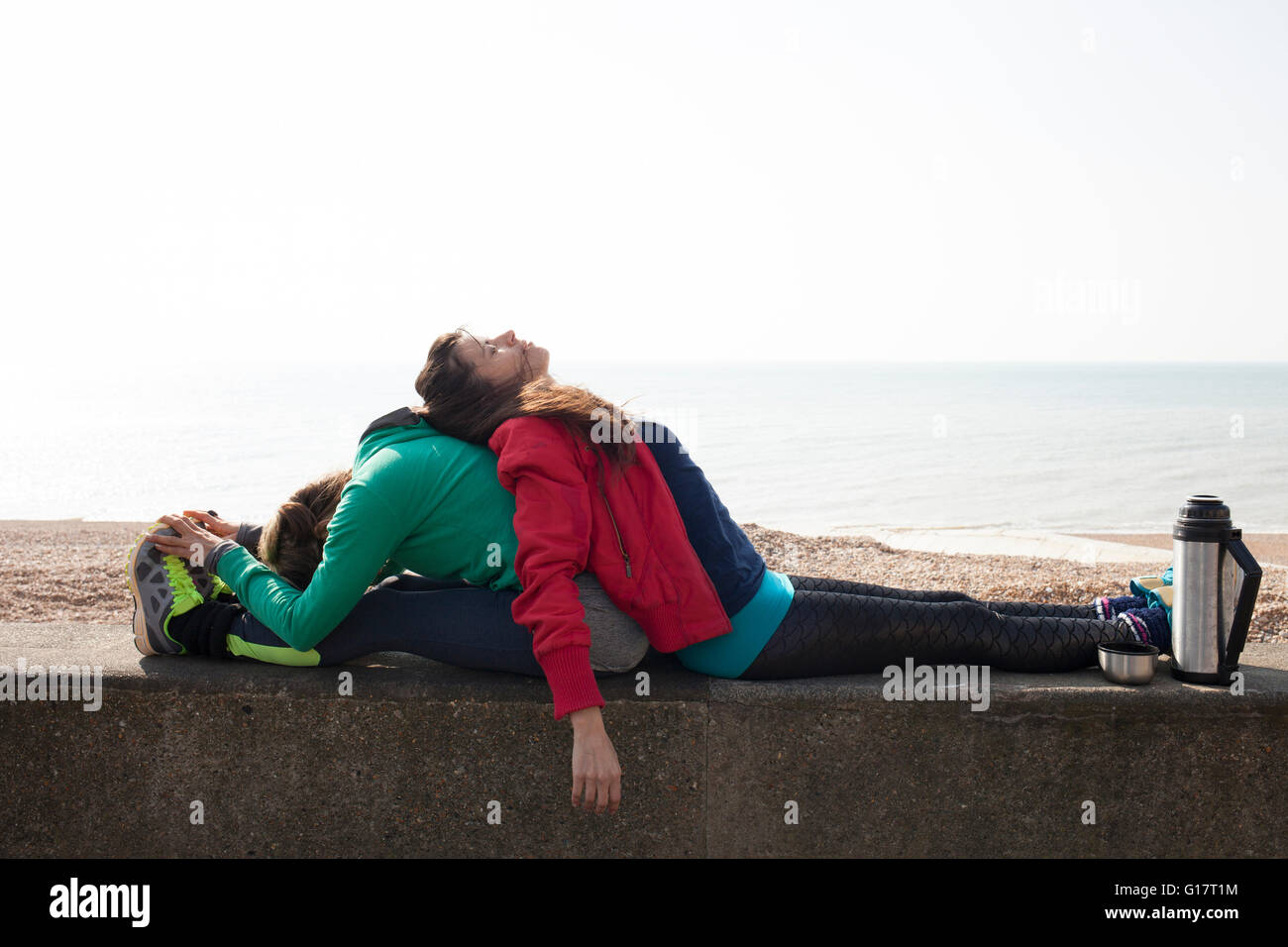 Épuisé dames appuyé contre l'un l'autre sur le mur à la plage de Brighton Banque D'Images