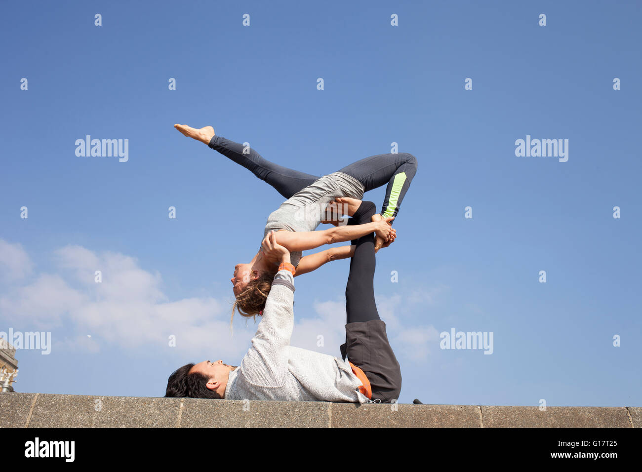 L'homme et la femme sur le mur pratiquer yoga acrobatique Banque D'Images