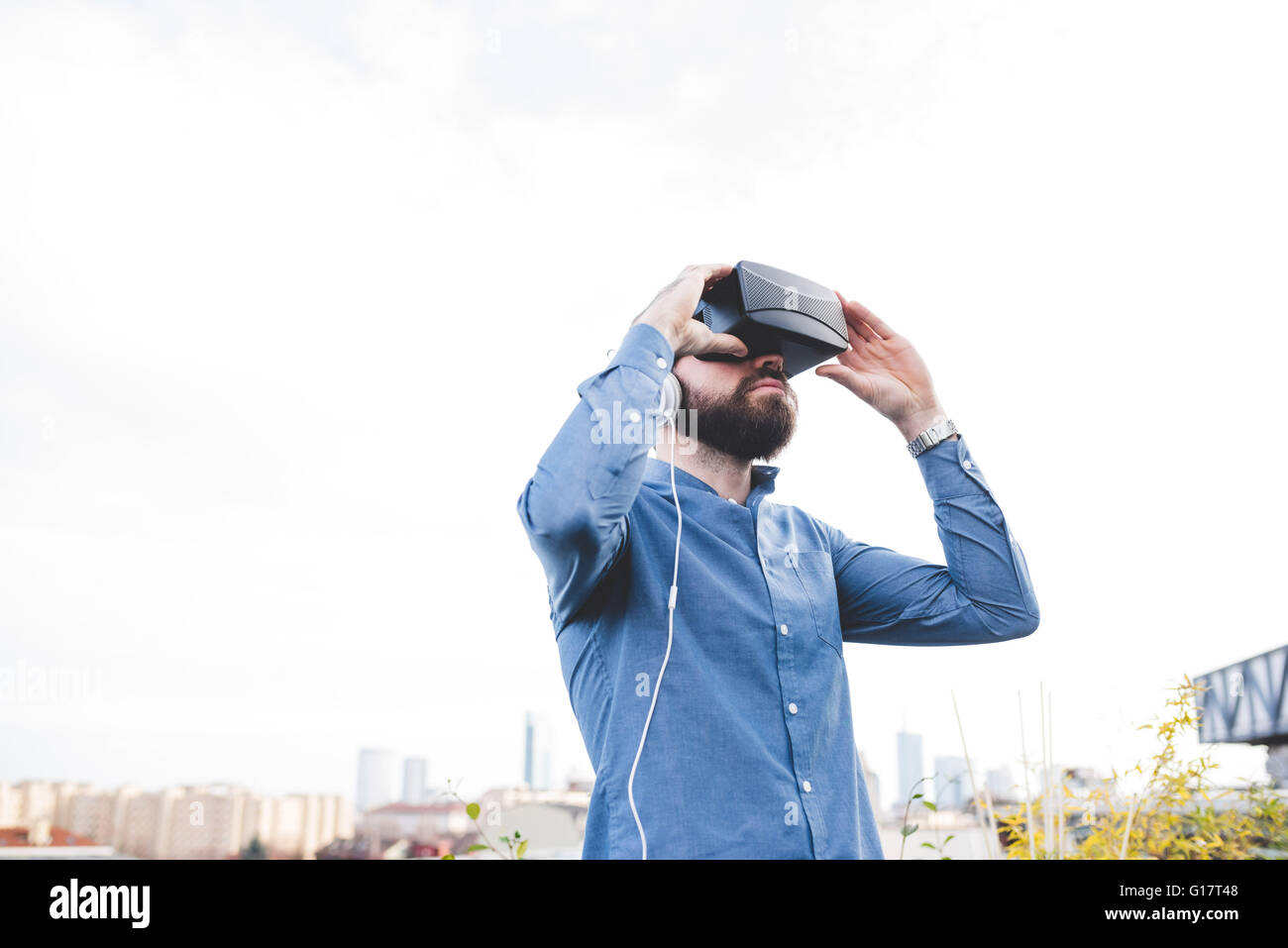 Jeune homme test designer casque de réalité virtuelle sur le toit-terrasse de l'office Banque D'Images