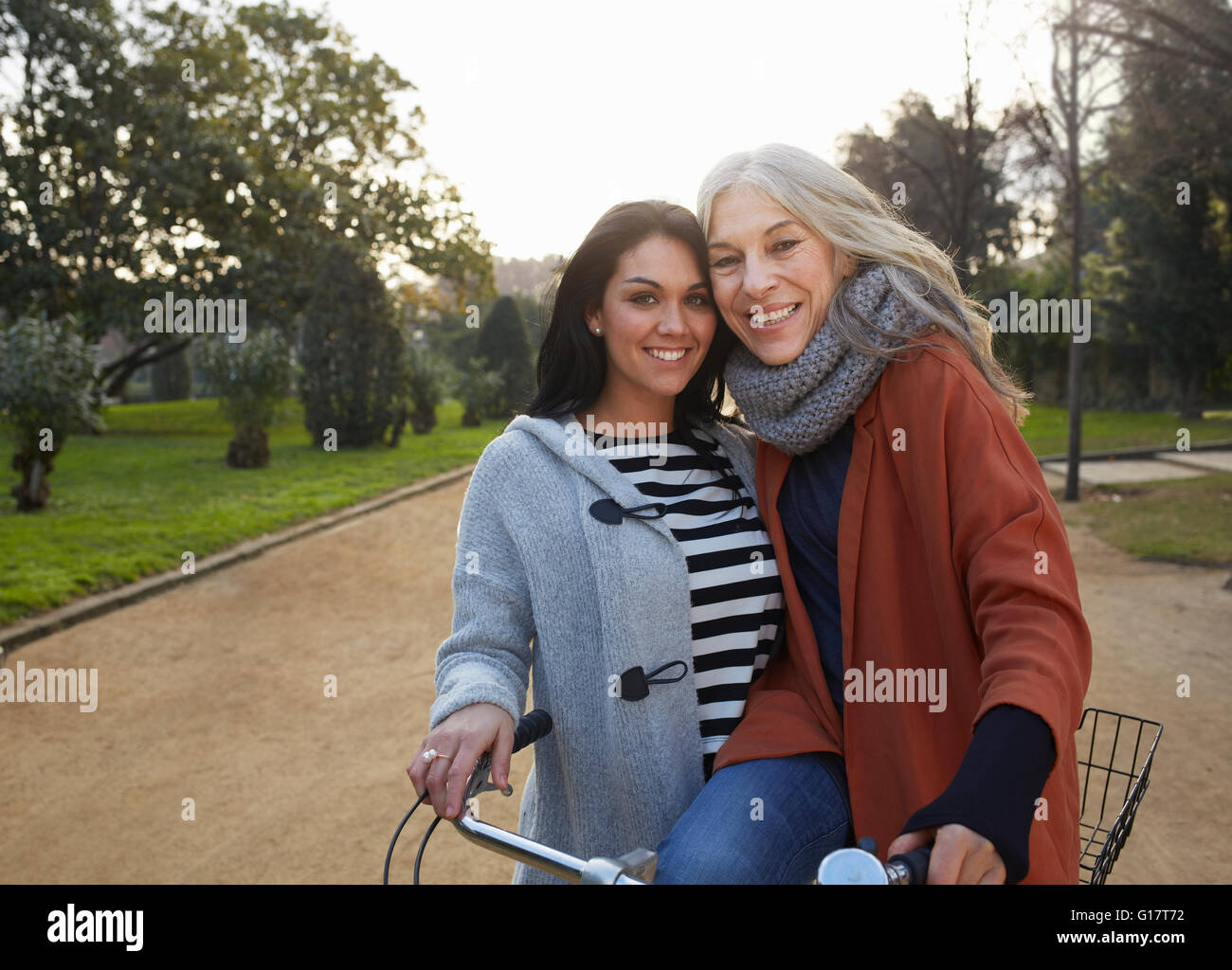Mère et fille adultes en parc avec location à la caméra en souriant Banque D'Images