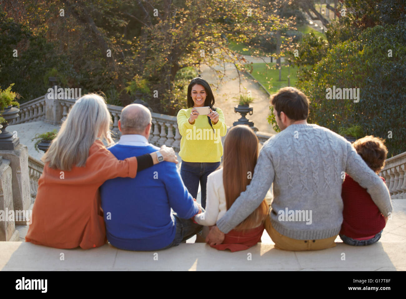 Mid adult woman using smartphone pour prendre des photo de famille dans park Banque D'Images