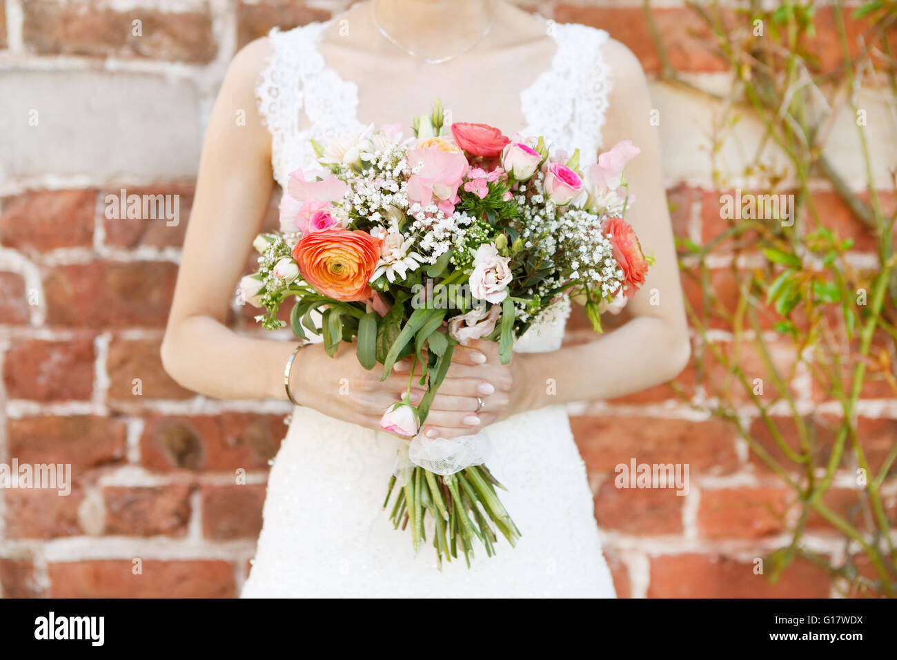 Une mariée en robe blanche tenant un bouquet de mariage, pas de visage Banque D'Images