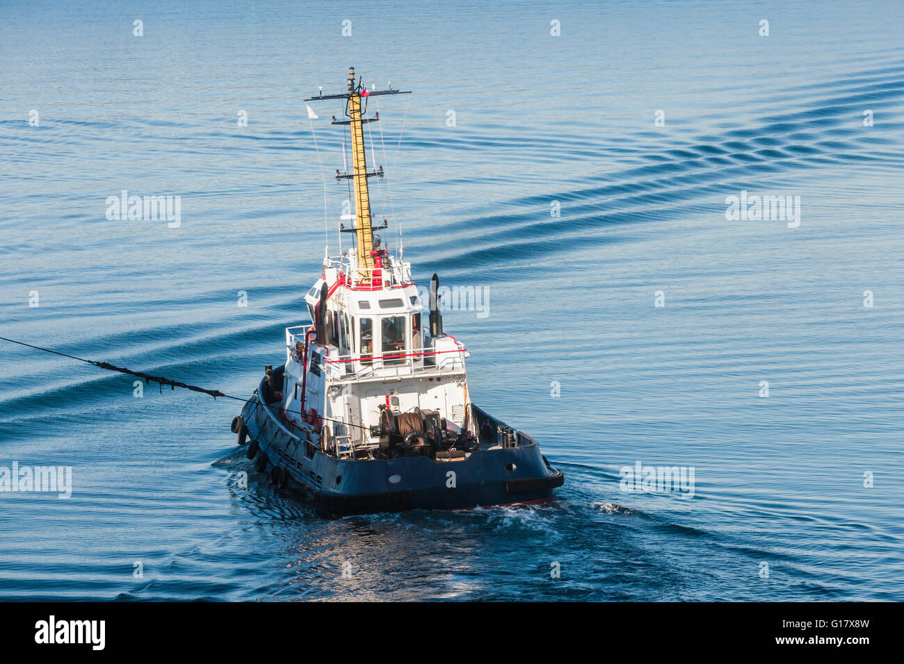 Tug boat avec superstructure blanc en cours en tirant sur la corde, vue arrière Banque D'Images