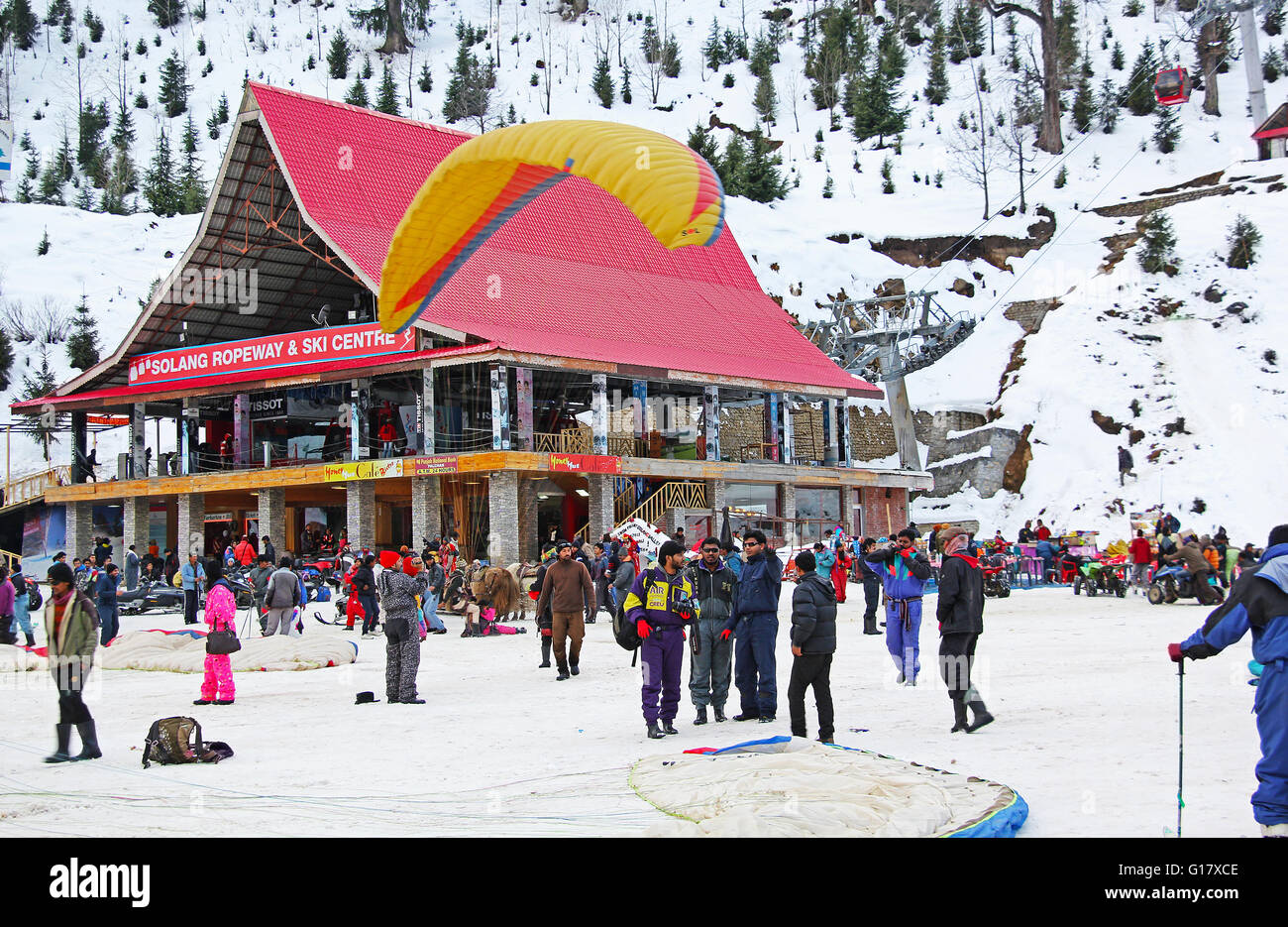 Les touristes engagés dans le parapente, le ski et autres sports au centre de sports d'hiver à Solang Valley de l'Himalaya à Manali, Inde. Banque D'Images
