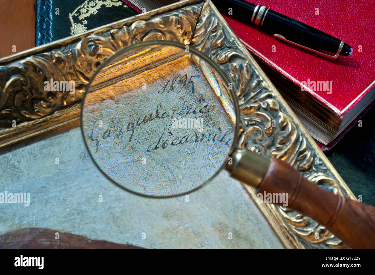 VENTE AUX ENCHÈRES PROVENANCE ARTISTE PEINTURE SIGNATURE VERRE loupe agrandissement signature XIXe siècle peinture à l'huile italienne avec cahier d'art expert et stylo Banque D'Images