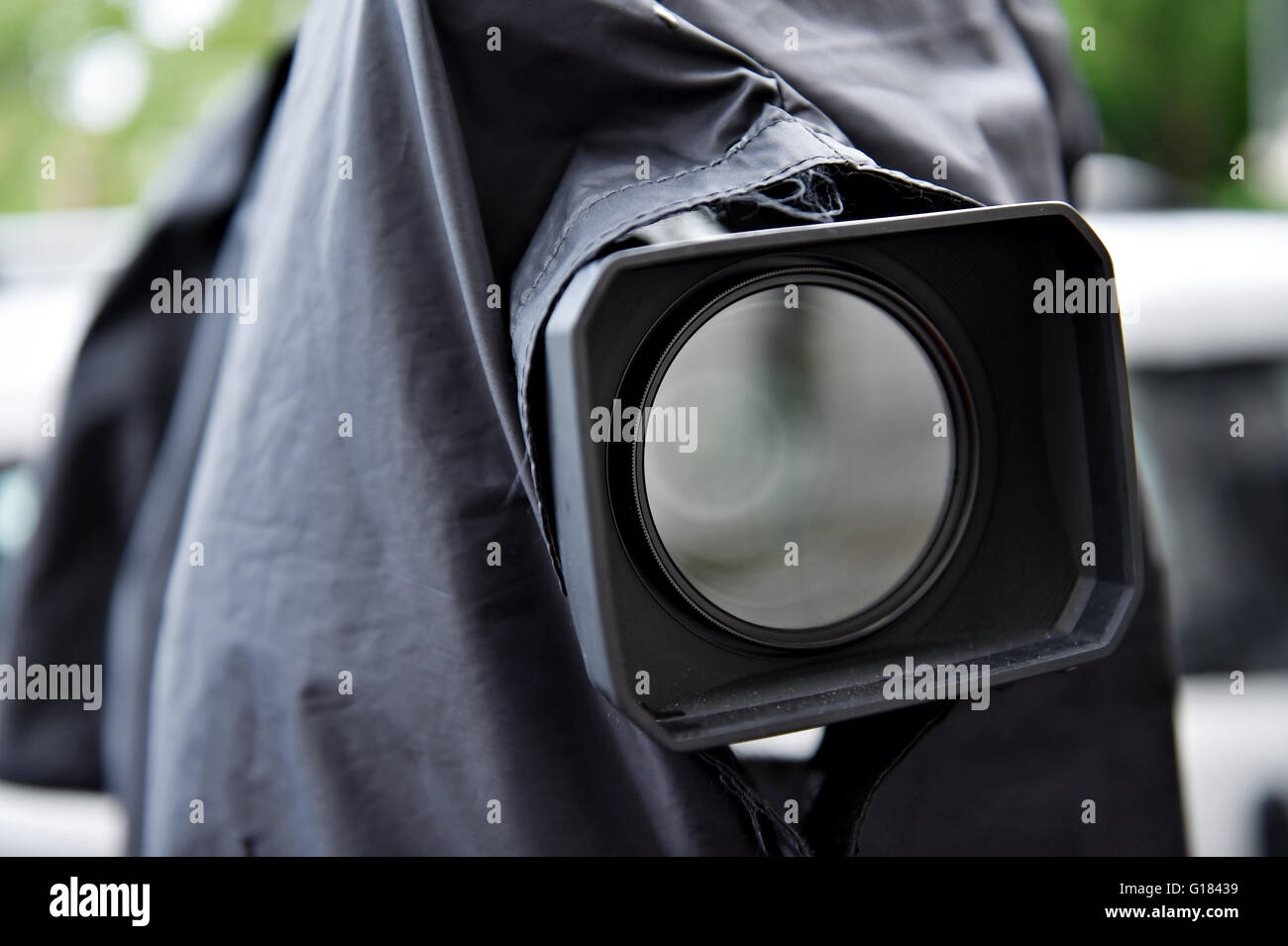 News appareil photo sur un trépied, protégé par une couverture de pluie noire Banque D'Images