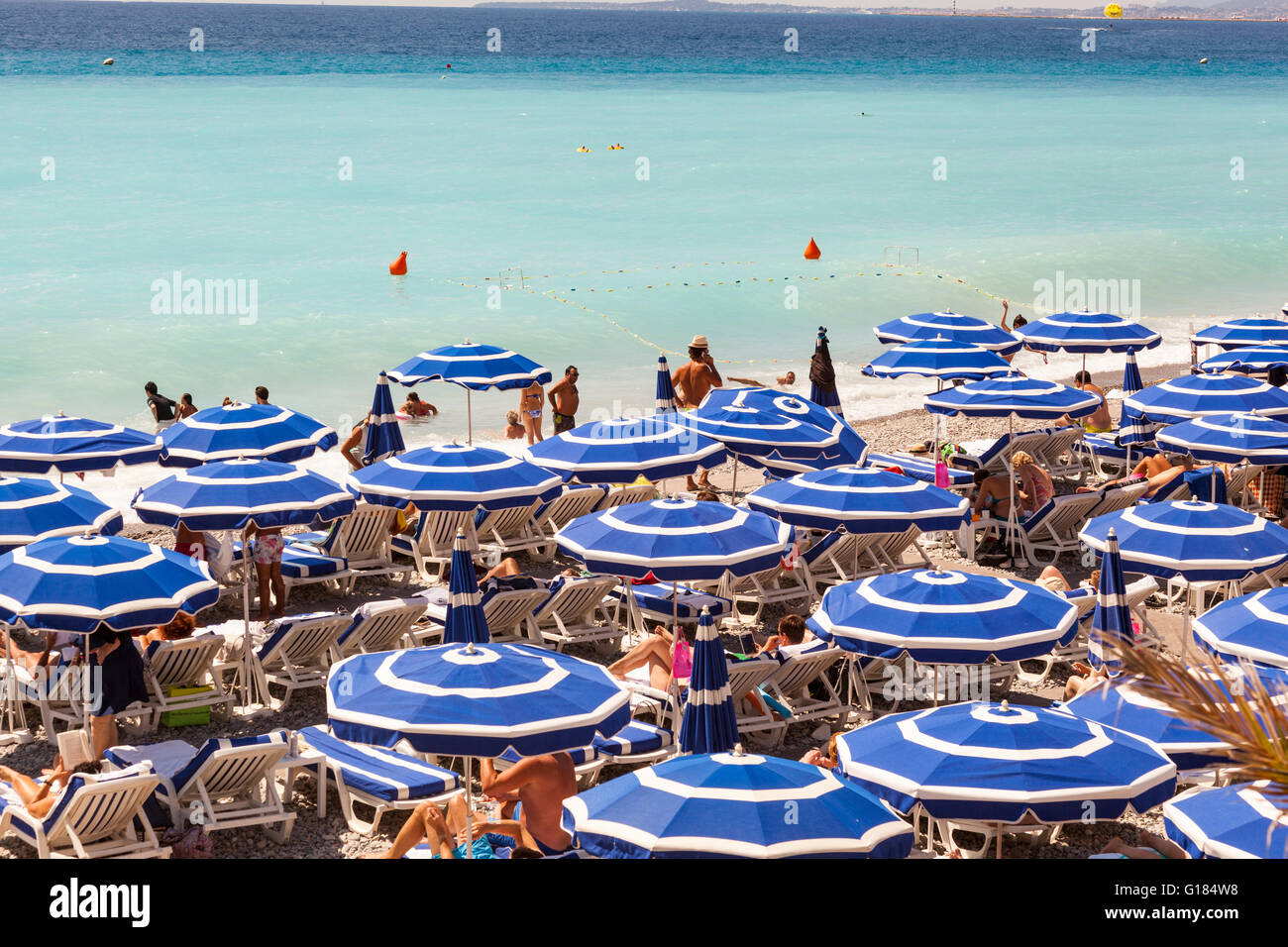 Baie des Anges et le bleu parasols sur la plage, Nice, Côte d'Azur, France Banque D'Images