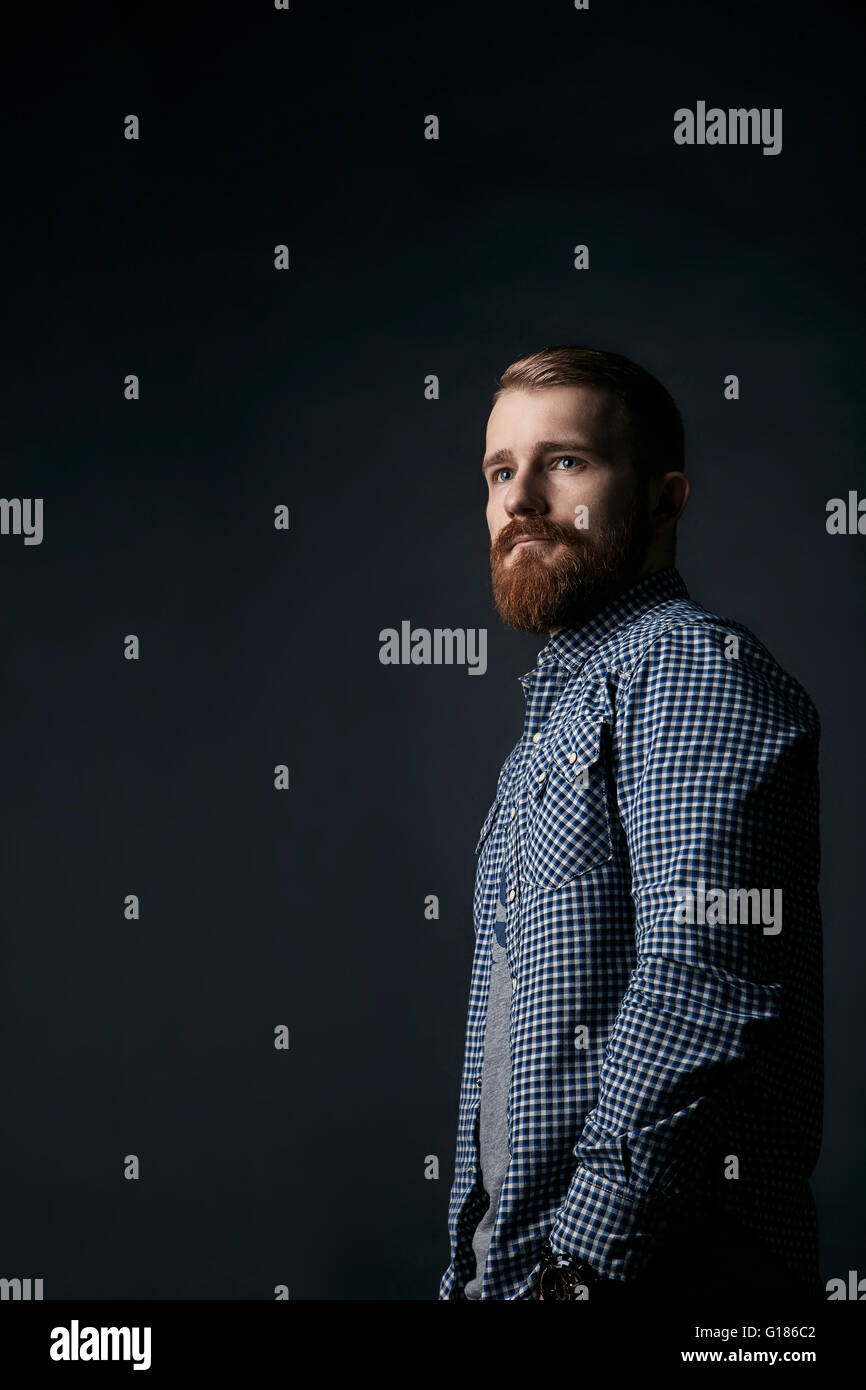 Homme barbu rouge pensive portrait studio sur fond sombre Banque D'Images