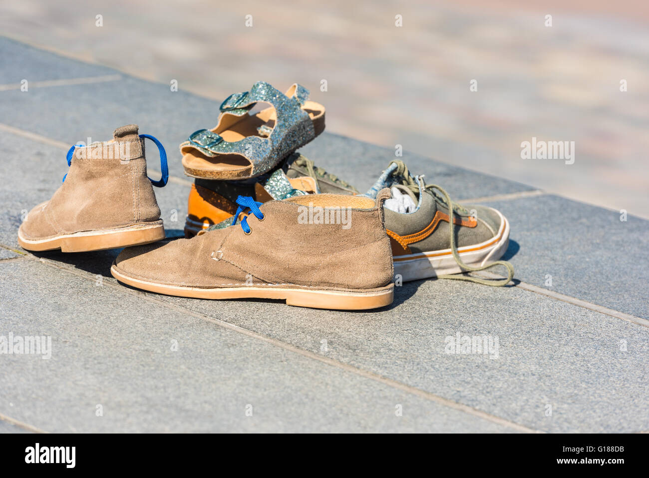 Chaussures de la famille laissée sur un trottoir dans une rue. Plan horizontal Banque D'Images