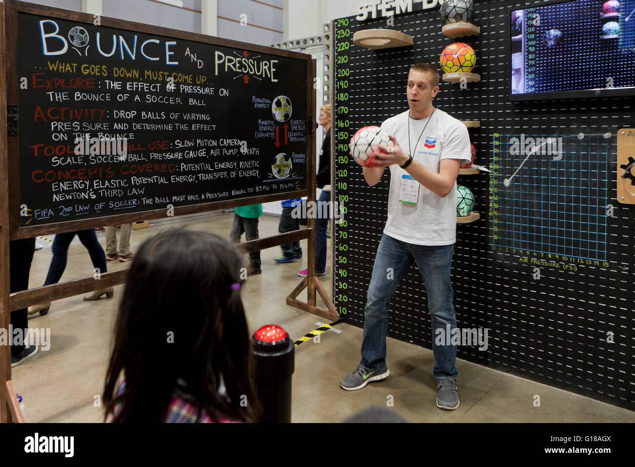 Un scientifique démontrant le potentiel de l'énergie et l'énergie cinétique avec le soccer ball bounce at science fair - USA Banque D'Images