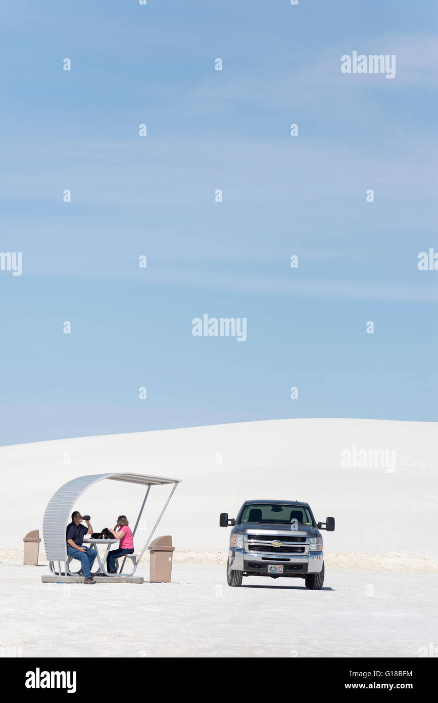 Couple picknicking sous ombrage abri dans White Sands National Monument, Nouveau-Mexique. Banque D'Images