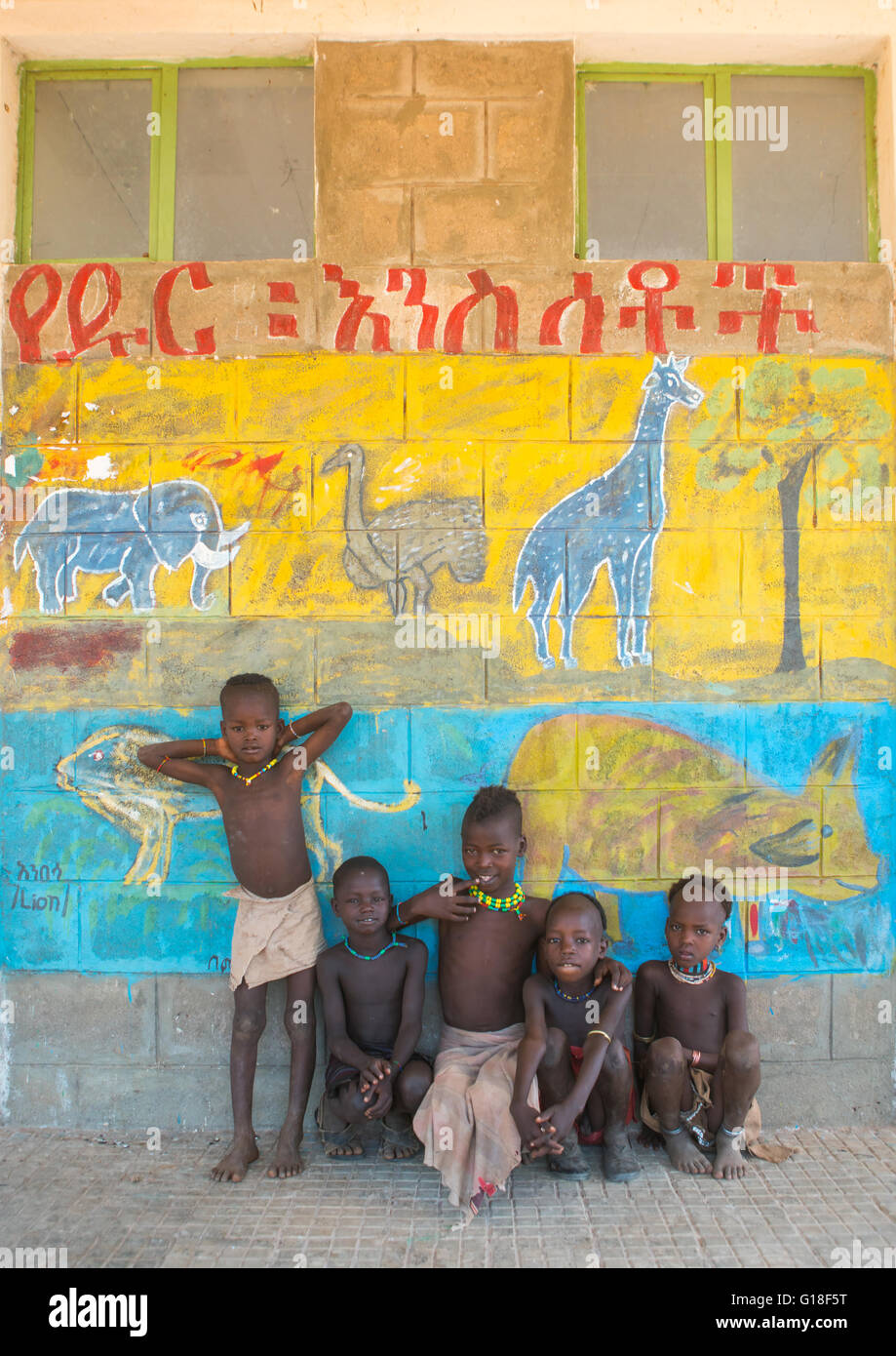 Tribu Hamer enfants dans une école en face d'un mur peint avec les animaux sauvages, vallée de l'Omo, Ethiopie, Turmi Banque D'Images