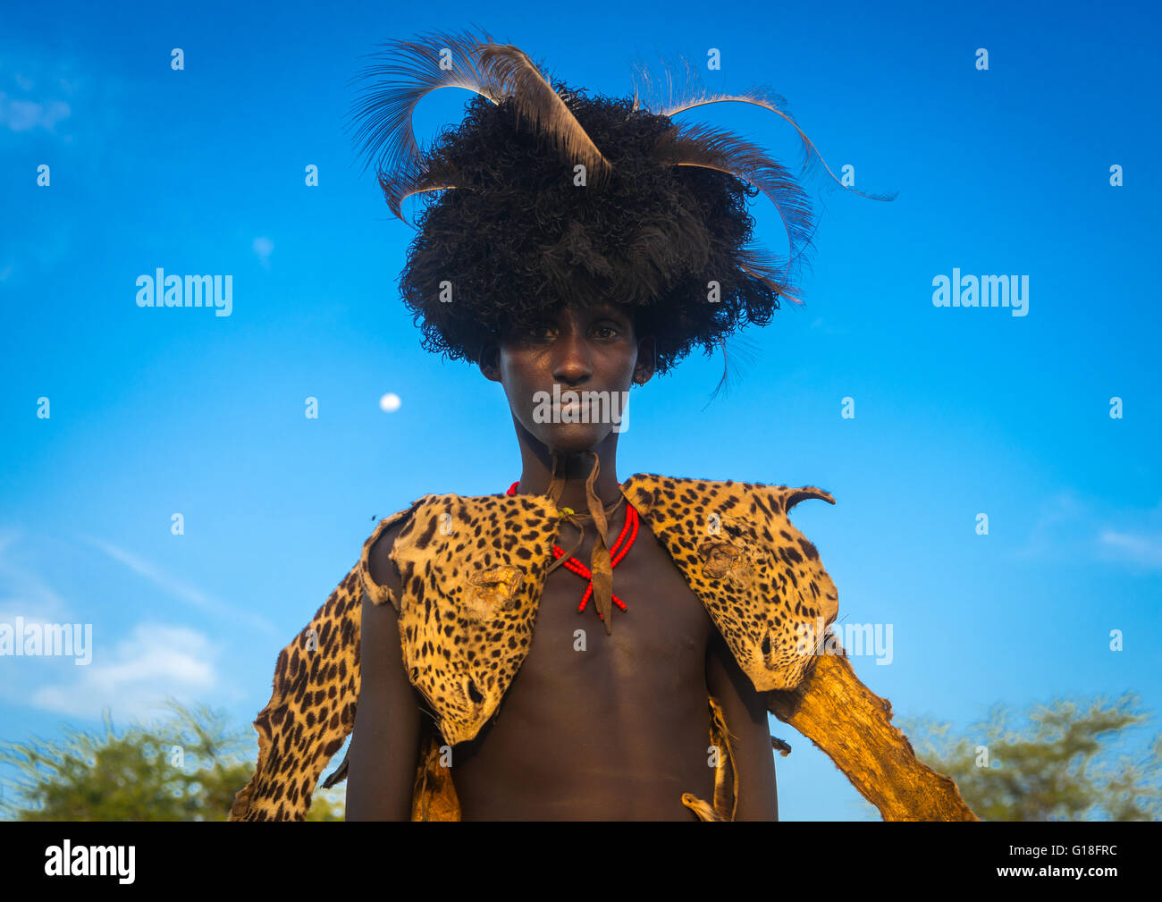 Dassanech homme avec léopard et plumes d'autruche au cours de coiffure cérémonie dimi pour célébrer la circoncision des adolescents, Omo v Banque D'Images