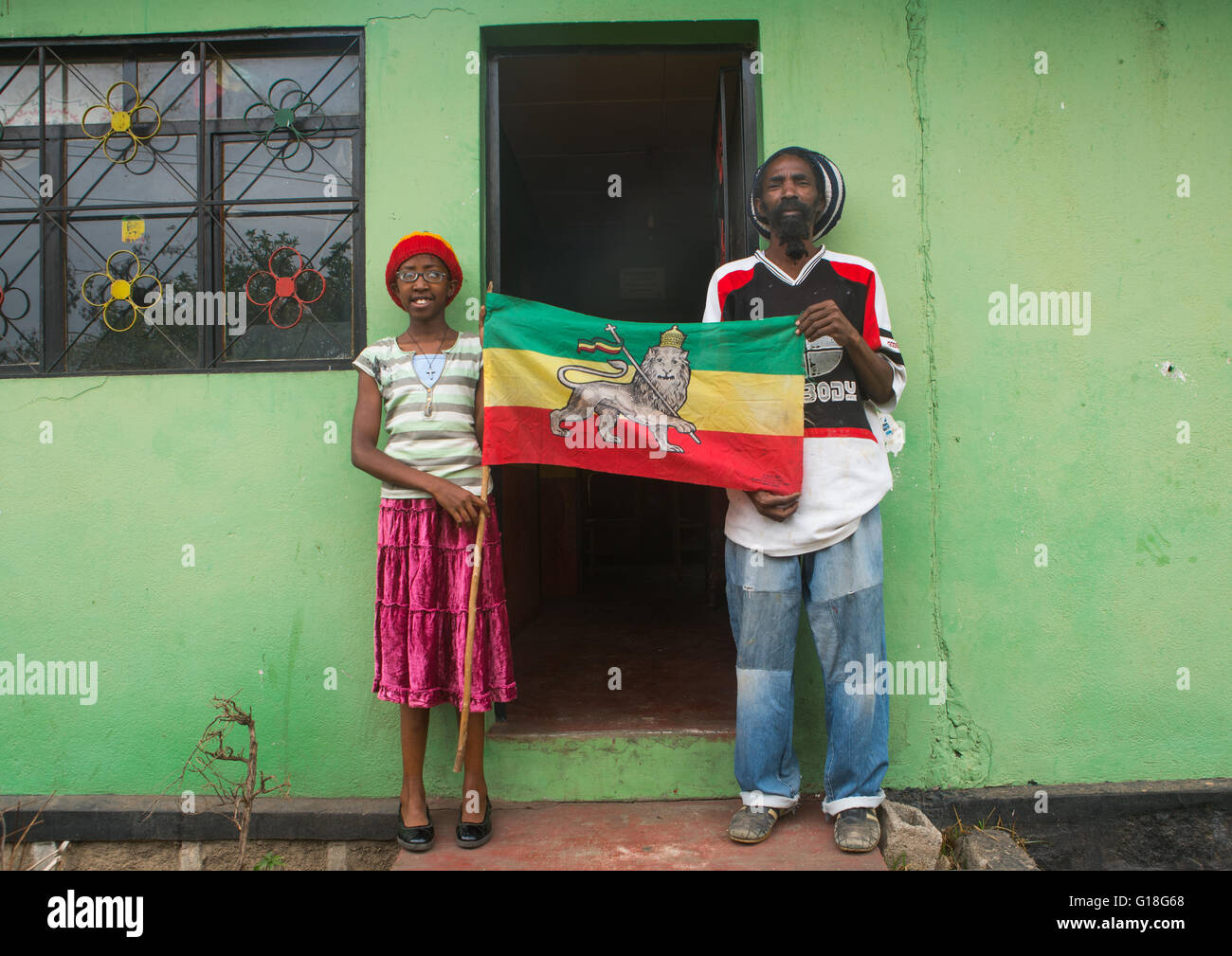 Rastafari fille appelée kizzy tenant un drapeau avec son père, Oromo, Shashamane, Ethiopie Banque D'Images