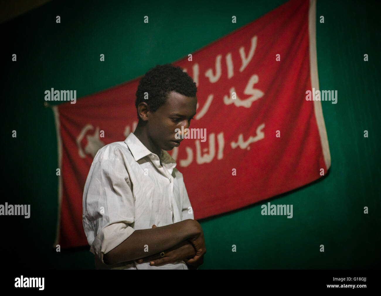 Homme soufi adorateur en face du drapeau rouge islamique, Harari région, Harar, Ethiopie Banque D'Images