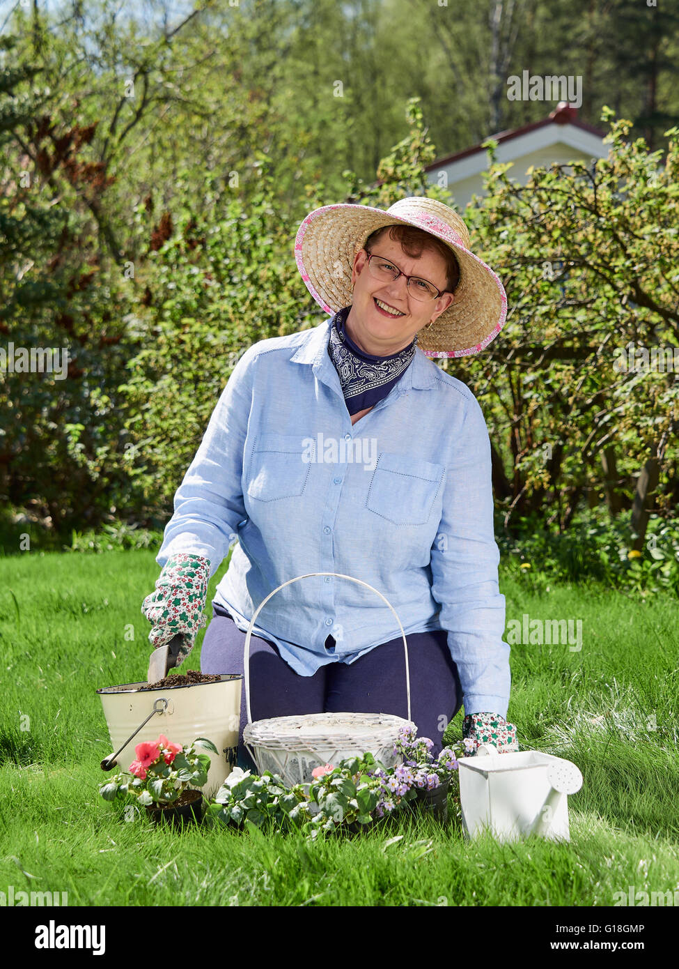 Femme mature, elle jardinage planter des fleurs Banque D'Images