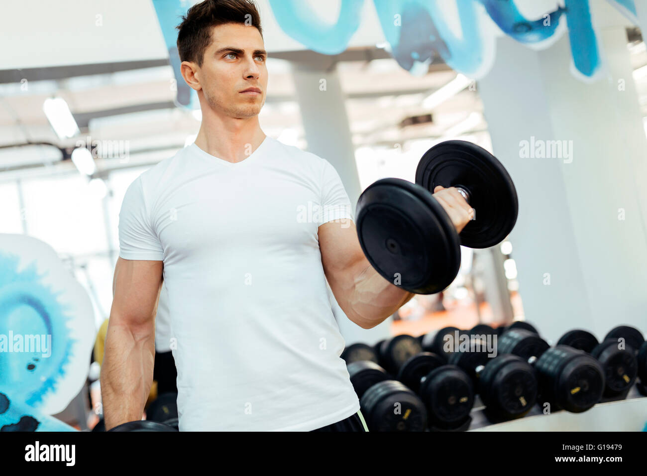 Handsome man lifting weights in gym et demeurer en forme Banque D'Images